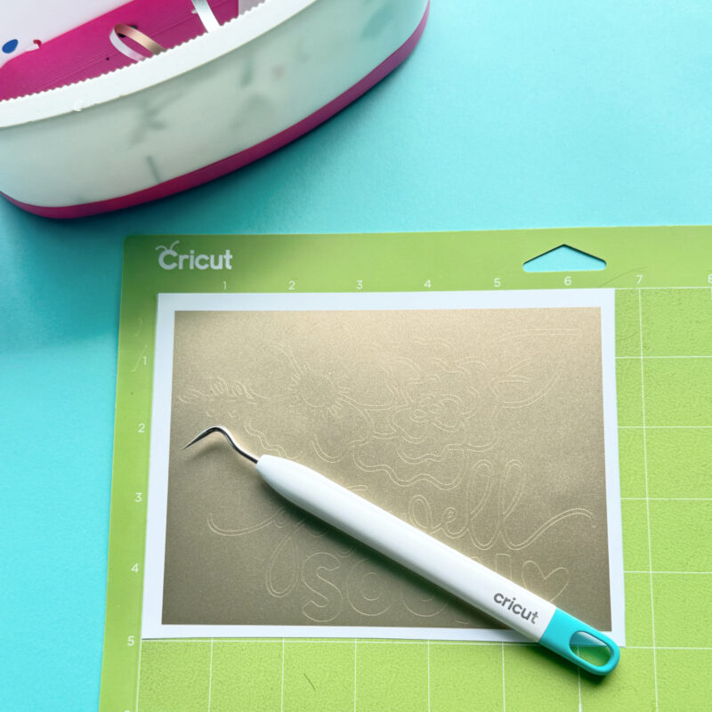 Use a pair of scissors to cut your vinyl around the box that you cut around your design. Remove the extra vinyl from around the box. I like to leave my vinyl on the Cricut Mat to help keep the design in place.