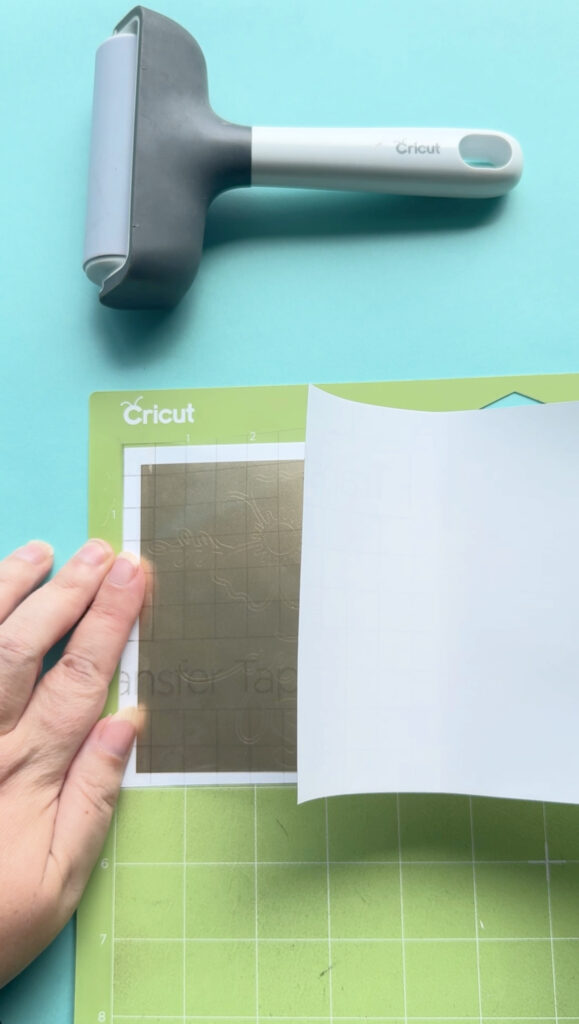 Burnish well using a scraper (the XL one is great for large designs). Then flip your "sandwich" over on your mat so that the transfer tape is now on the bottom, the vinyl decal in the middle and the vinyl backing is on top. Burnish again.