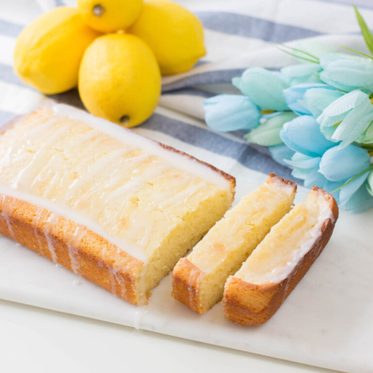Glazed Lemon Loaf with lemons, tulips and a kitchen towel