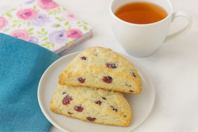 Scones with notebook, cup of tea and tea towel