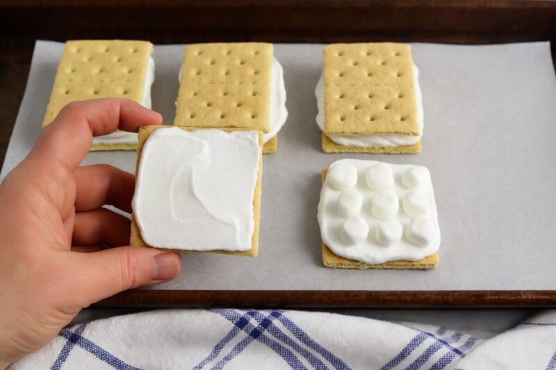 Step 3: Add the tops Spread a thin layer of whipped topping on the remaining graham cracker halves and press them on top to form sandwiches.