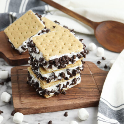 Cool off with this Frozen S&rsquo;mores Recipe! A quick and easy summertime treat your whole family will love! With just a few simple ingredients like marshmallows, whipped topping, and graham crackers, these no-bake frozen sandwiches are perfect for hot days, BBQs, and backyard fun.