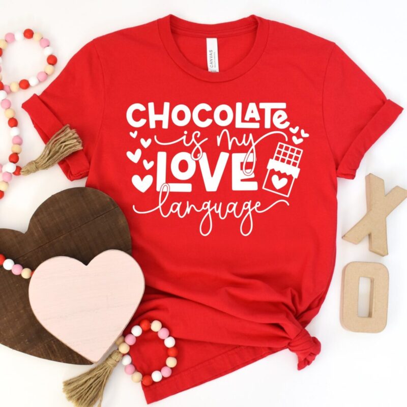 Red t-shirt mockup featuring the phrase “Chocolate Is My Love Language” with hearts and a chocolate bar graphic.