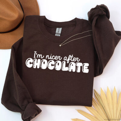 Brown sweatshirt mockup featuring the phrase “I’m nicer after chocolate” in playful white lettering.