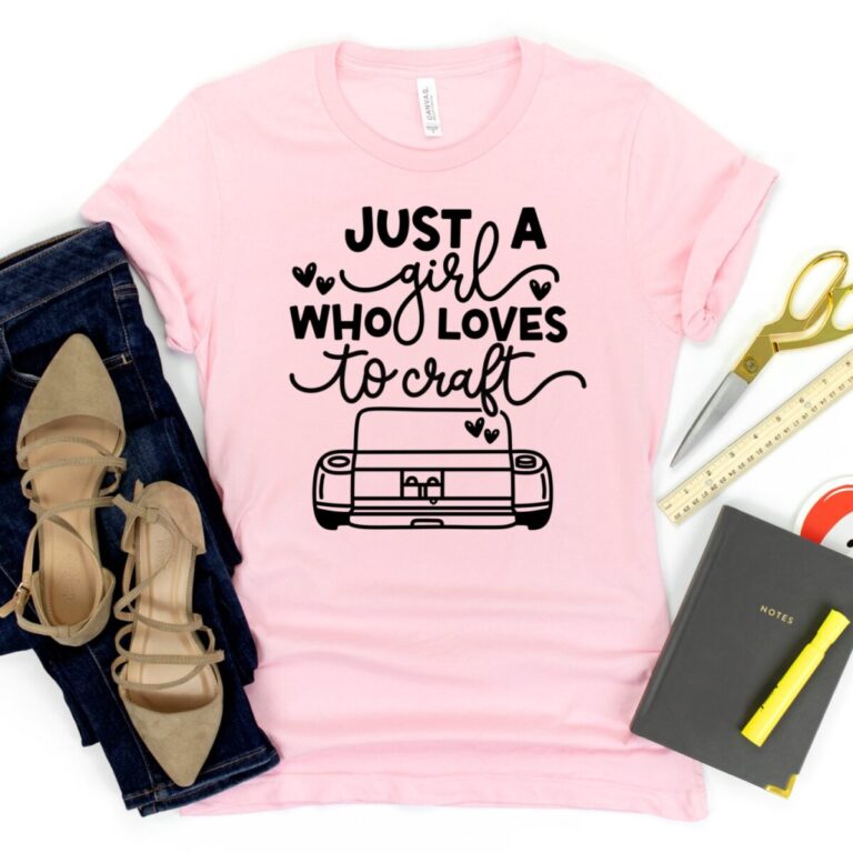 Pink t-shirt mockup featuring the phrase “Just a Girl Who Loves to Craft” with a Cricut-style cutting machine graphic, styled with jeans, scissors, ruler, and craft supplies.